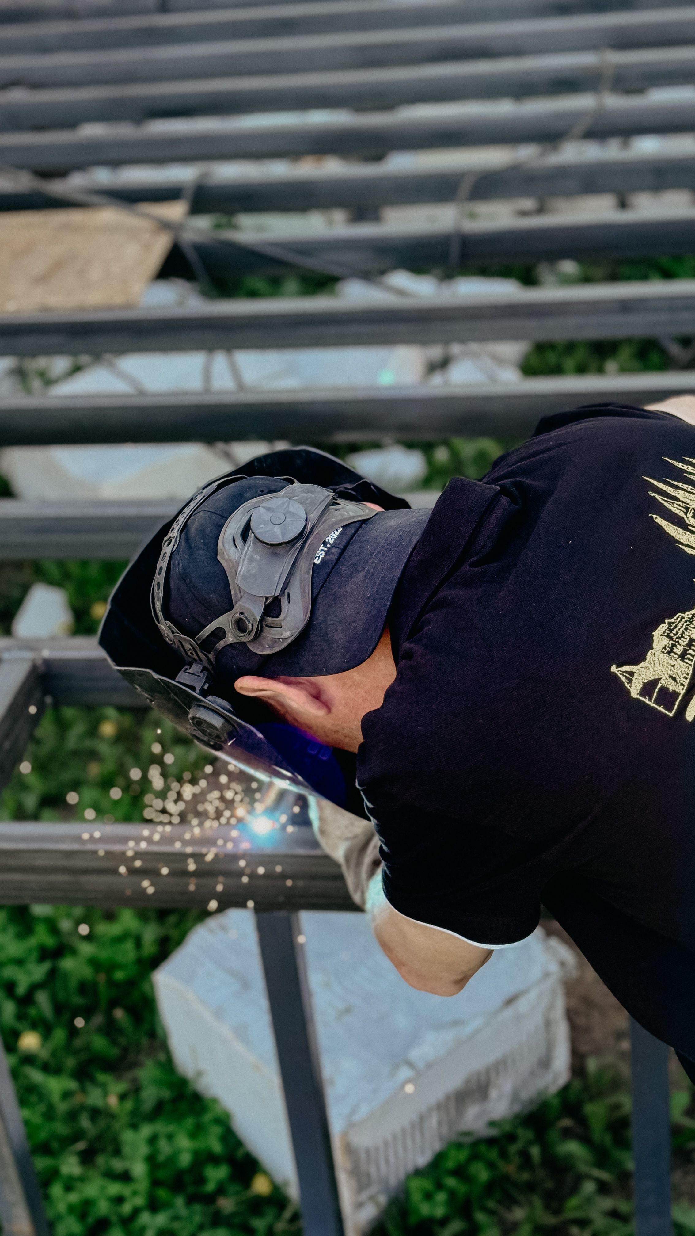 Overhead view of a welder fabricating a steel fence frame